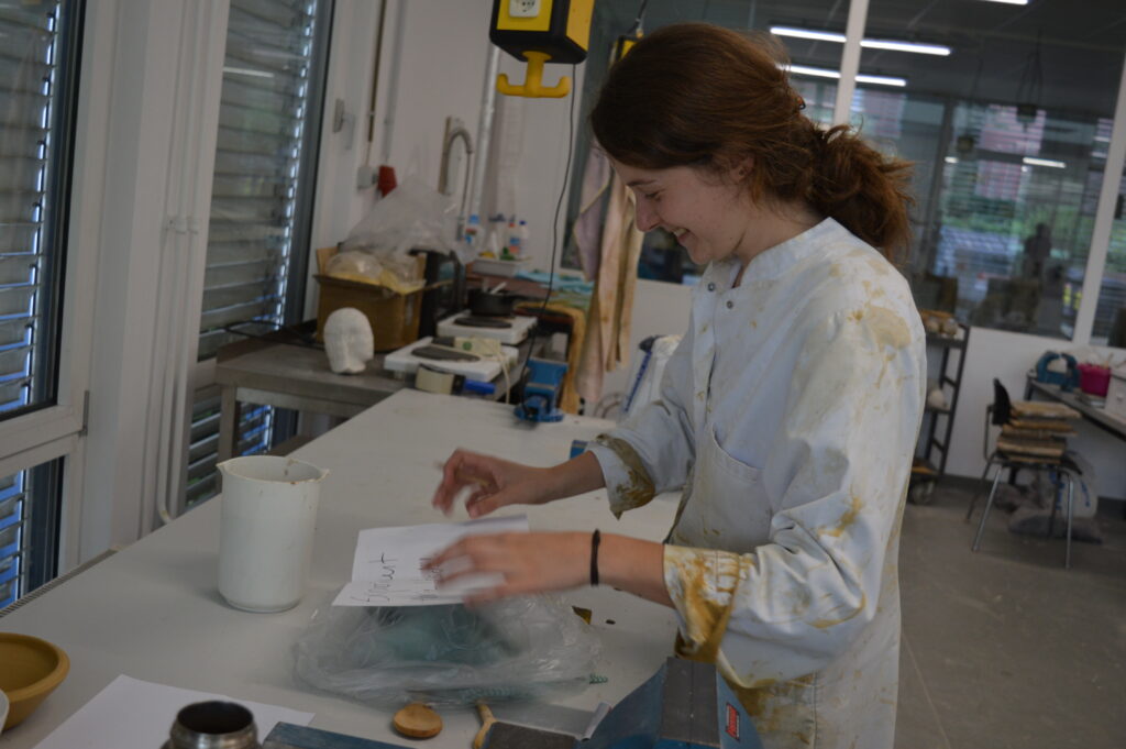 Das Bild zeigt Marie Usadel im Laborkittel bei der Vorbereitung eines Experiments.