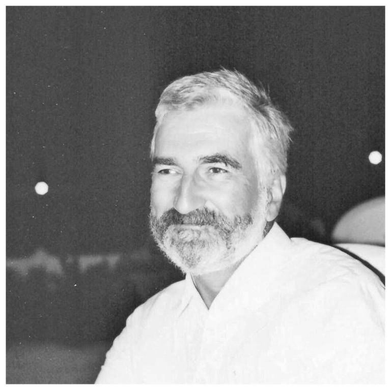 Schwarzweiß Foto von Prof. Dr. Hans Lohmann, er trägt ein hoch geknöpftes weißes Hemd, sein Blick ist nach vorn gerichtet, sein weißgraues Haar und sein Vollbart reflektieren das Licht.