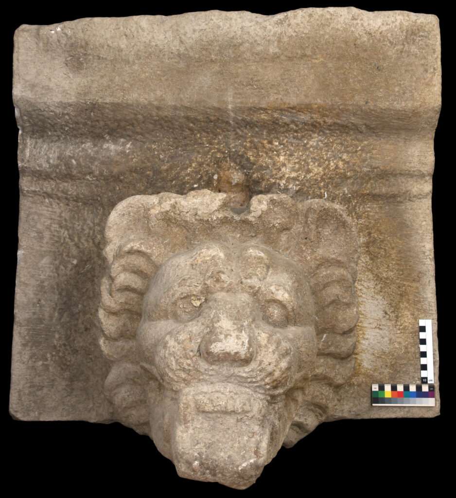 Detail der Sima mit Löwenkopf. Man sieht gut, dass der Kopf nur zum Teil fertig ausgearbeitet ist und zum anderen Teil noch in Bosse verblieben ist.